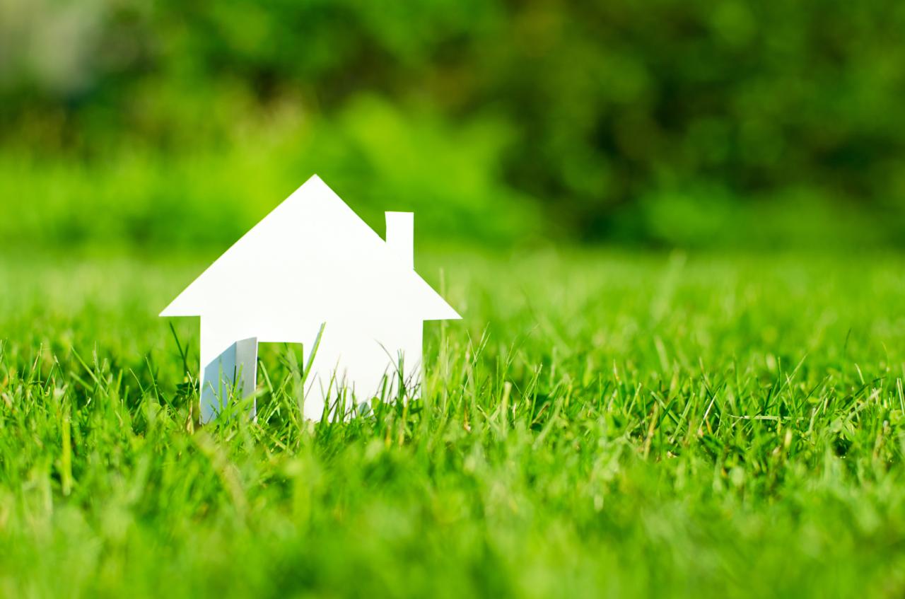Maison en papier sur un pré vert pour un chauffage écologique par pile à combustible dans une maison familiale
